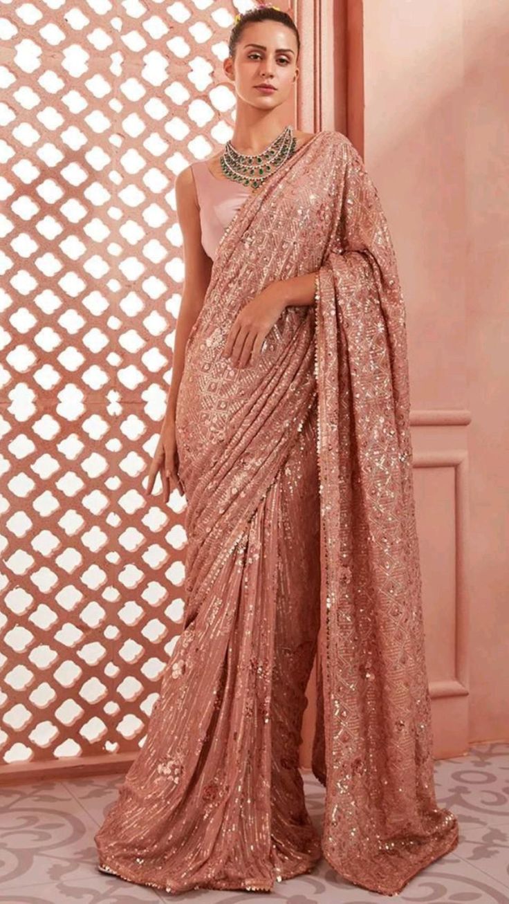 Peach sequined saree against a lattice screen